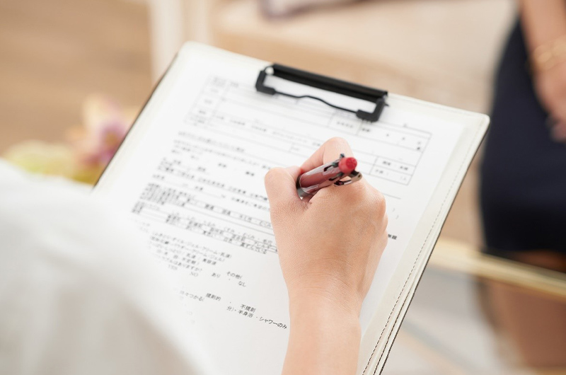 問診票のような紙に記入している様子